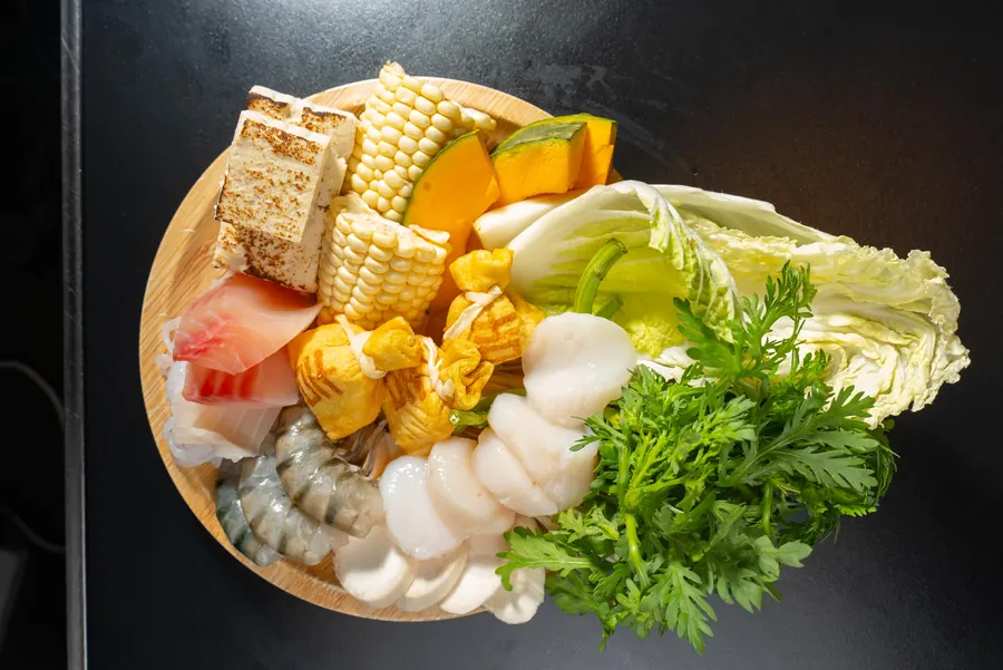Cabbage, corn, tofu, greens and seafood for the pot