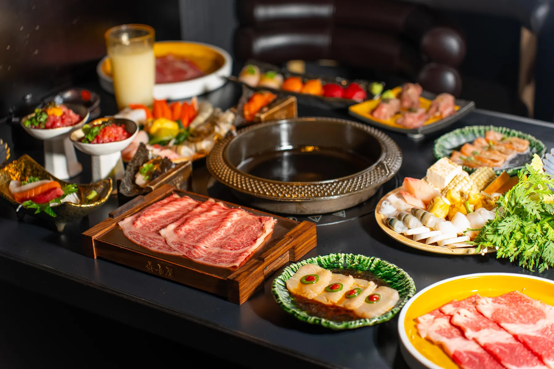 A table set with wagyu, seafood and sides, ready for the pot